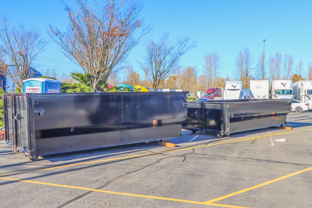 Professional dumpster rental service with roll-off container on residential driveway in Manvel